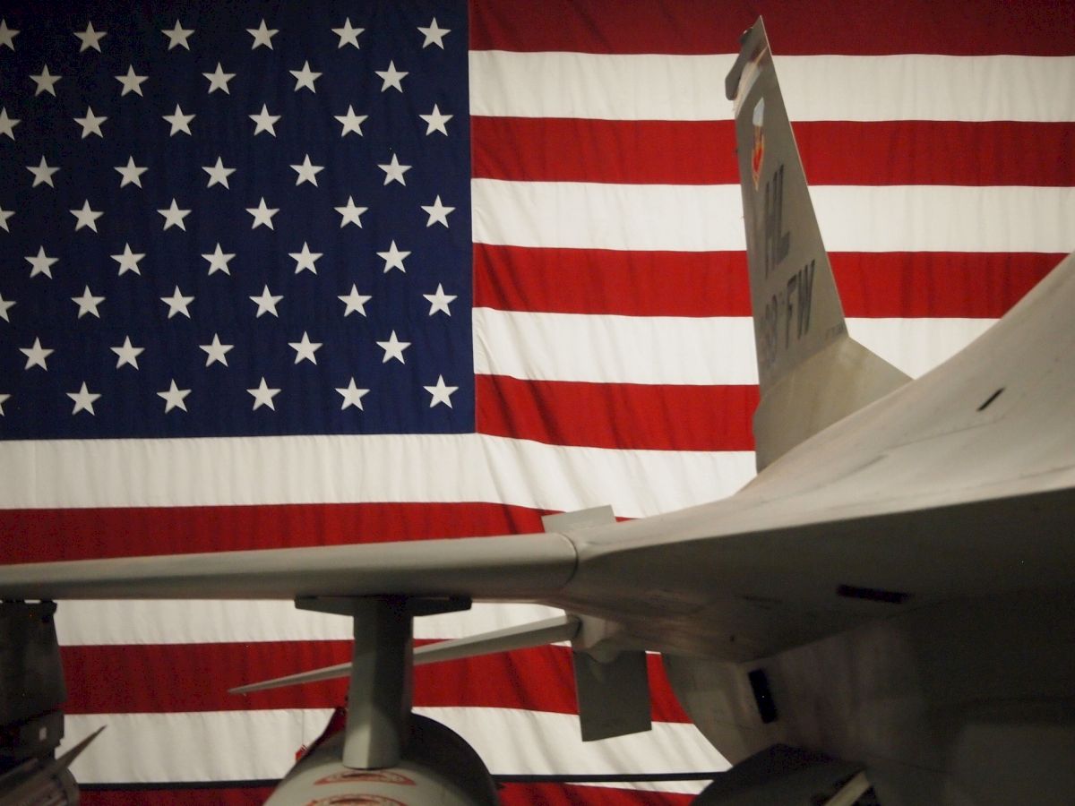 An aircraft is shown in front of a large American flag, highlighting a patriotic display.