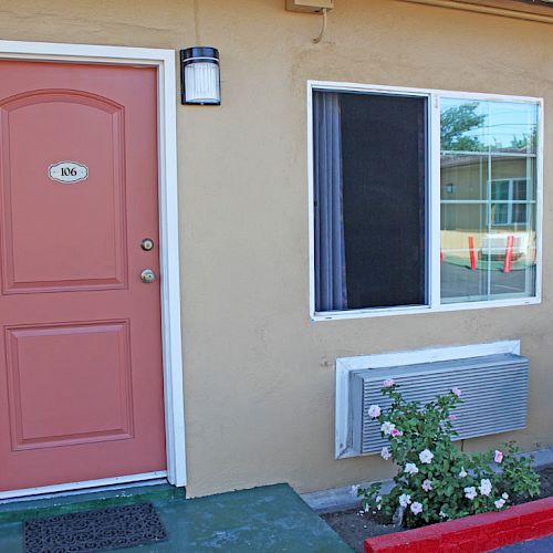 An exterior view of a building with a red door labeled 