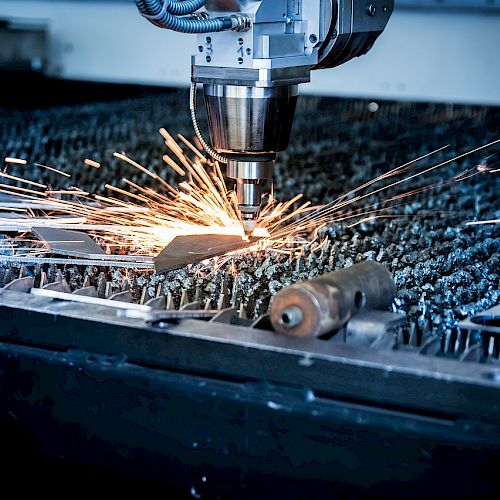 A CNC machine is cutting metal, creating sparks as it shapes the material, with precision automation tools visible in the background.